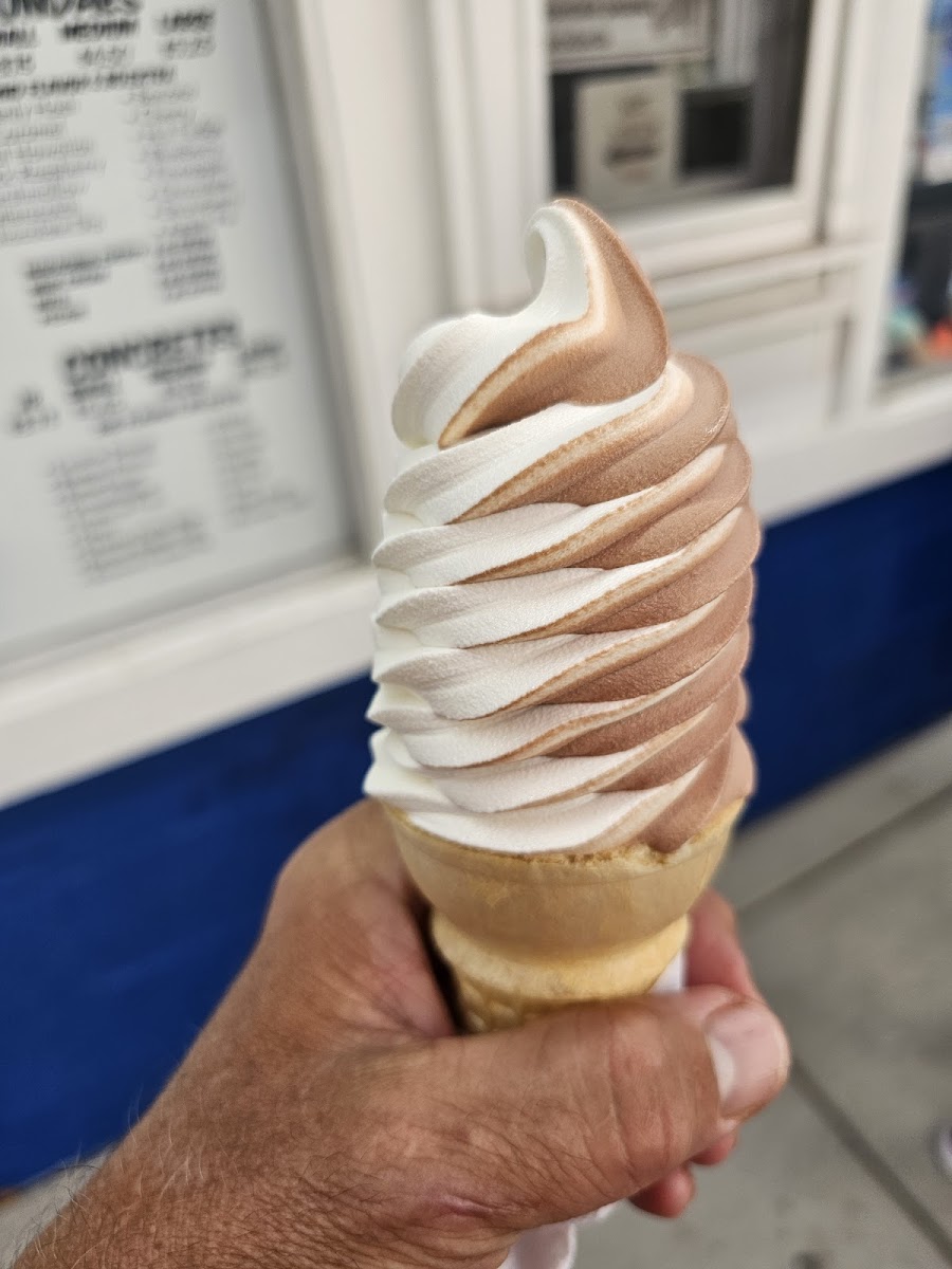 A chocolate and vanilla twist cone in front of Dairy Haven’s blue service counter